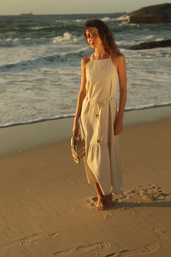Modelo com vestido dourado junto ao mar